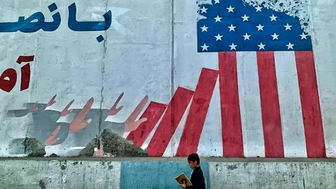 Un niño afgano camina frente al muro de la antigua enbajada de Estados  Unidos en Kabul donde han pintado un mural anti imperialista. Foto: A. F. Reca
