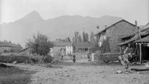 Riaño. Häuser & Berge [Viviendas típicas de piedra con troncos apoyados en el exterior y montañas]