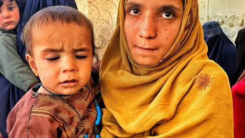 Un grupo de mujeres y niños esperan su turno de vacunación en un centro sanitario rural en distrito de Nerkh, en Maidan Wardak, Afganistán. Foto: Alfonso F. Reca