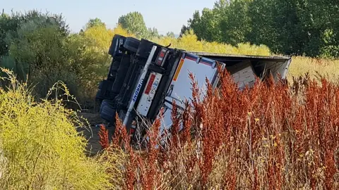 Imagen del camión volcado en la madrugada de este miércoles en en la LE-11, en la glorieta del punto limpio de León.