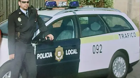Gabriel Llamas, Policía Local de León, junto a un vehículo policial de la Unidad de Tráfico.