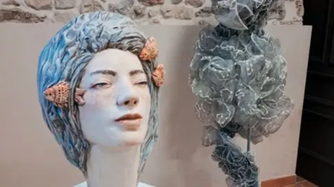 Escultura cerámica de Cathy Thompson y escultura textil de Elena Campos.