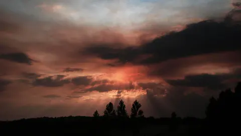 El humo de los incendios provoca un ocaso teñido de rojo en León. Foto: Peio García