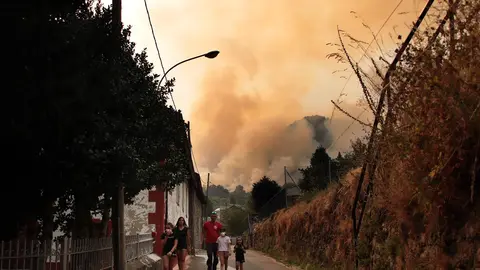 Varios vecinos observan el fuego.