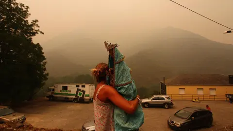 Una vecina de Lusio (León), rescata la Santa del pueblo ante la posible llegada del fuego. Fotos: César Hornija