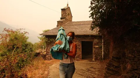 Una vecina de Lusio (León), rescata la Santa del pueblo ante la posible llegada del fuego. Fotos: César Hornija