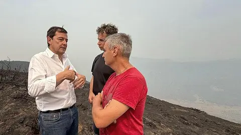 El presidente de la Junta, Alfonso Fernández Mañueco, conversa con vacinos de Laciana afectados por el fuego este domingo en Orallo. Foto: JCyL