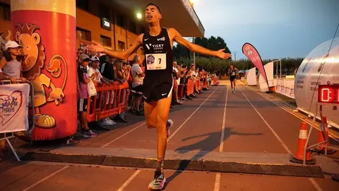 Imagen del ganador de la carrera de la Legua Nocturna de Santa María del Páramo cruzando la línea de meta.