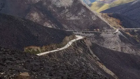 El Alto del Morredero, escenario final de la decimoséptima etapa de La Vuelta a España 2025, ofreció este miércoles unas imágenes impactantes. El fuego que arrasó la comarca de Llamas de Cabrera ha transformado un paraje verde y lleno de vida en un paisaje desértico y negro, salpicado por algunos árboles y matojos que recuerdan la riqueza natural que antes albergaba el monte.