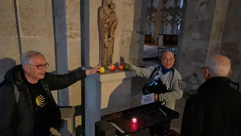 Tomás Álvarez y Norman Sinclair fotografiados poniendo la manzana, ante la estatua de la Virgen y el Niño, en St María im Kapitol.