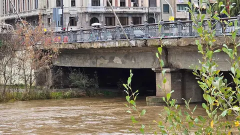 La crecida del río Bernesga a su paso por la capital leonesa llevó este viernes al Ayuntamiento de León a cerrar las pasarelas peatonales que comunican ambos márgenes del cauce. Fotos: Carlos Calvo | Silvia García