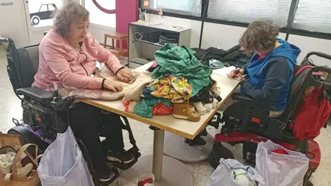 Dos voluntarias del CRE de San Andrés del Rabanedo clasifican y ordenan las prendas que después se entregan a las familias.