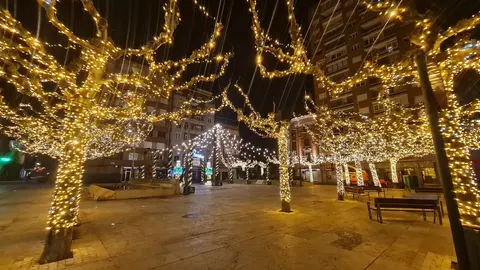 La Plaza de las Cortes de León ha estrenado estos días una imagen con el mejor sentimiento navideño. Sus árboles, se envuelven en un resplandor que domina la zona desde el atardecer, convirtiéndola en uno de los enclaves más llamativos del inicio de la Navidad de la mano de Caja Rural.