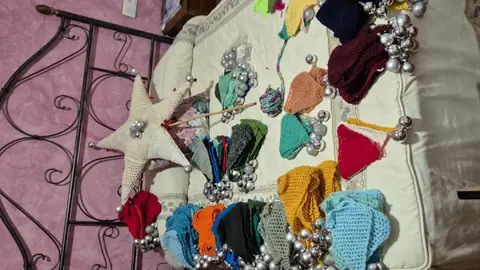 Concepción García Riol, vecina del pueblo leonés, cumple su sueño navideño tras medio año tejiendo en secreto un árbol único que ya ilumina la plaza mayor. Su hija Patrocinio y su amiga Encarna la ayudaron a levantarlo.