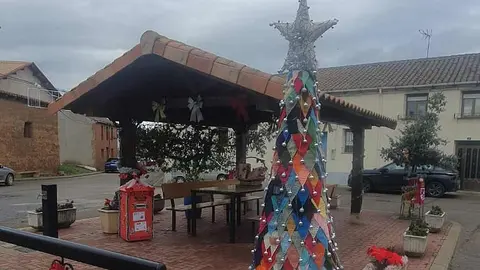 Concepción García Riol, vecina del pueblo leonés, cumple su sueño navideño tras medio año tejiendo en secreto un árbol único que ya ilumina la plaza mayor. Su hija Patrocinio y su amiga Encarna la ayudaron a levantarlo.