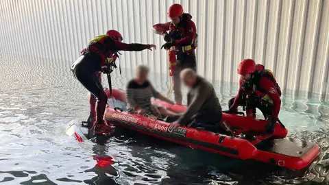 Bomberos de León intervinieron en el rescate de dos personas de avanzada edad que quedaron atrapadas en el interior de su vehículo tras quedar completamente anegado por el agua en la pasarela subterránea de la calle Príncipe, en San Andrés del Rabanedo. Fotos de Bomberos León