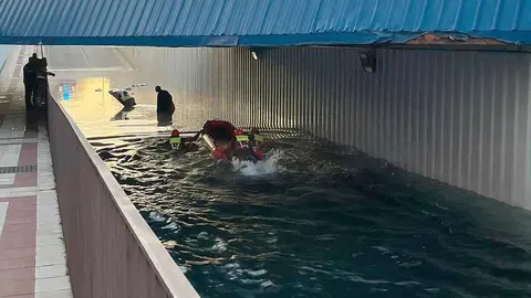 Bomberos de León intervinieron en el rescate de dos personas de avanzada edad que quedaron atrapadas en el interior de su vehículo tras quedar completamente anegado por el agua en la pasarela subterránea de la calle Príncipe, en San Andrés del Rabanedo. Fotos de Bomberos León