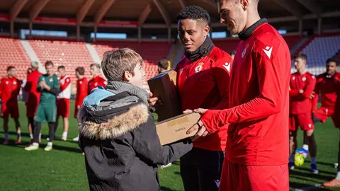 Los jugadores de la Cultural hacen entrega de los regalos del sorteo a los niños. Foto: Cultural.