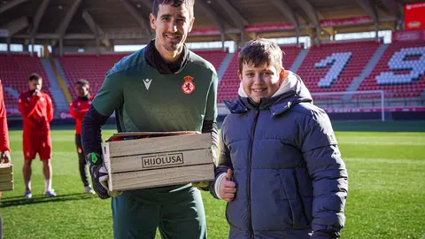Los jugadores de la Cultural hacen entrega de los regalos del sorteo a los niños. Foto: Cultural.
