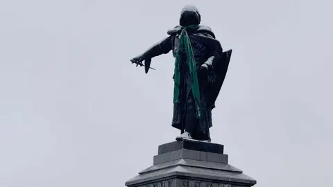 La estatua de Guzmán, en León capital, ha aparecido este miércoles con una bufanda verde recordando que en esta jornada se conmemora el Día Mundial contra el Cáncer. Fotos: Silvia García