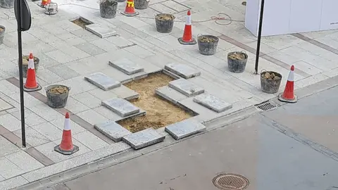 Renovación en Ordoño II: obras de mantenimiento y cambio de losetas en la principal arteria peatonal. El Ayuntamiento de León realiza intervenciones en zonas peatonales y de uso mixto para mejorar la seguridad y durabilidad del pavimento.