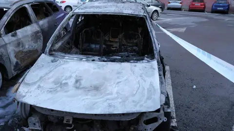Arden tres vehículos aparcados en La Virgen del Camino.