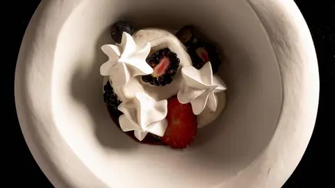 Pavlova de frutos rojos con helado de nata.