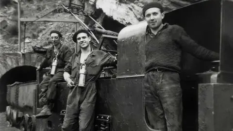 Segundo piso Calderón bocamina en el trole 1. Sentado, Julián el de la cuadra. De pie, Celso. Archivo fotográfico de Manuel Gancedo Fernández sobre la zona de Laciana. Imágenes mejoradas por Carlos Labrador.
