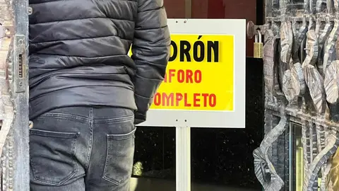 Un cartel 'fosforito' advierte de la imposibilidad de atender a nuevos migrantes que soliciten documentación en el padrón municipal. El proceso de regularización ha provocado una masiva presencia de demandantes de documentación, visible desde antes de que se abran las dependencias municipales. Fotos: Lucía Ramajo