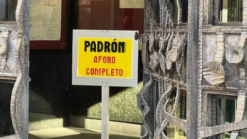 Un cartel 'fosforito' advierte de la imposibilidad de atender a nuevos migrantes que soliciten documentación en el padrón municipal. El proceso de regularización ha provocado una masiva presencia de demandantes de documentación, visible desde antes de que se abran las dependencias municipales. Fotos: Lucía Ramajo