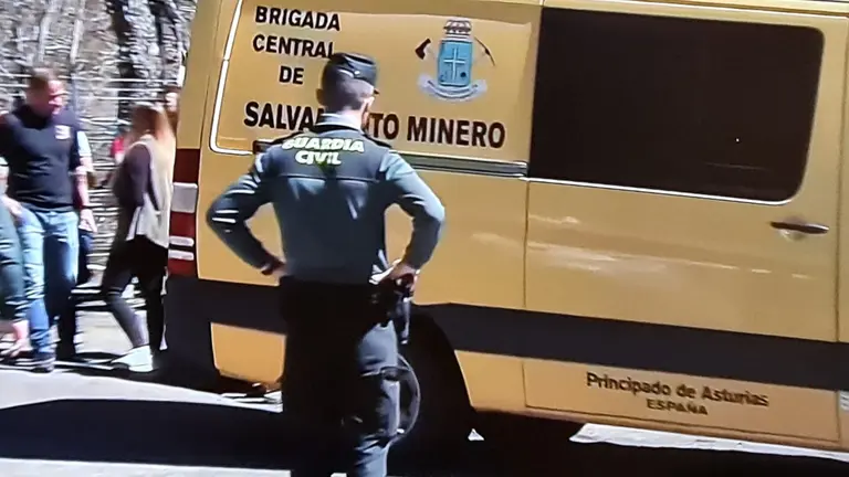Un guardia civil observa el paso de los equipos de salvamento minero junto a la bocamina de Cerredo.