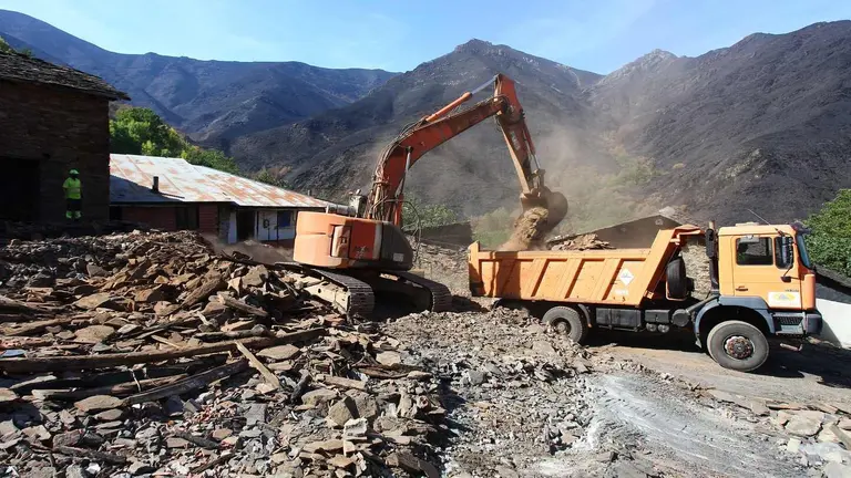 Trabajos de derribo y desescombro de las casas afectadas por el incendio en la localidad de Lusio.