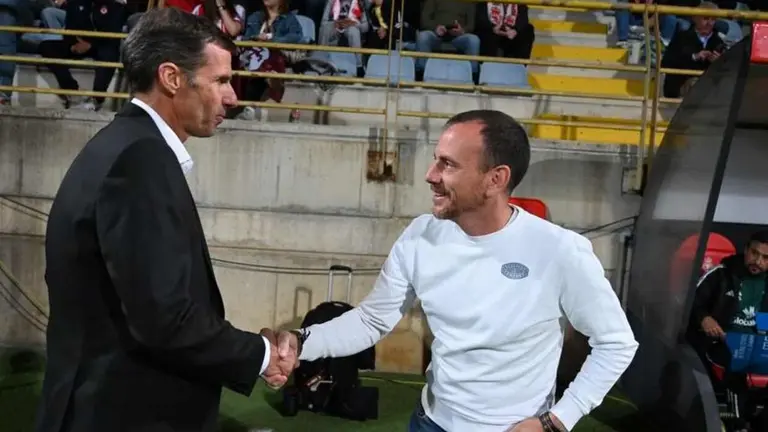 Los entrenadores se saludan momentos antes del inicio del partido.
