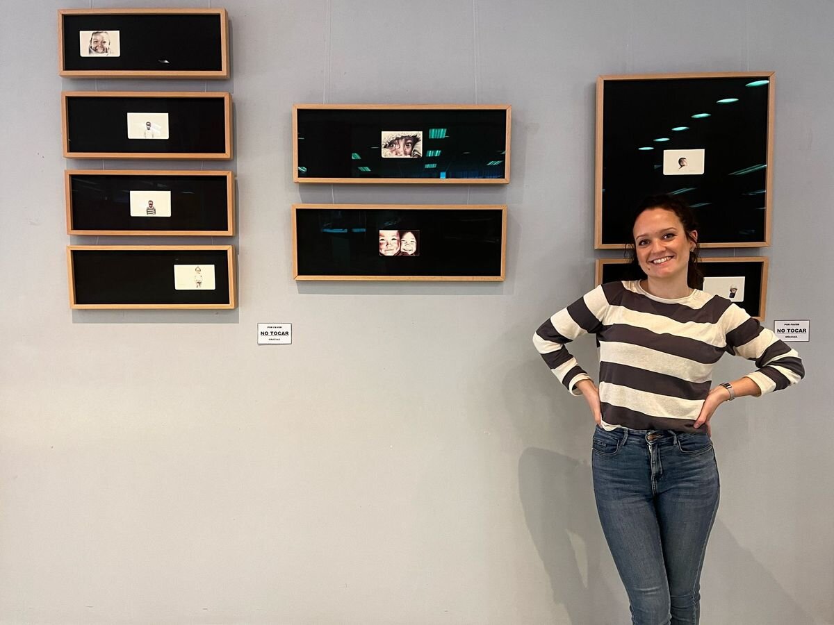 Marina junto a sus retratos a boli.