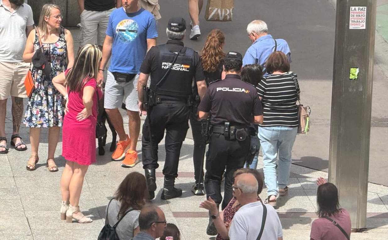 Efectivos de la Policía Nacional se llevan a una de las personas implicadas en el incidente.