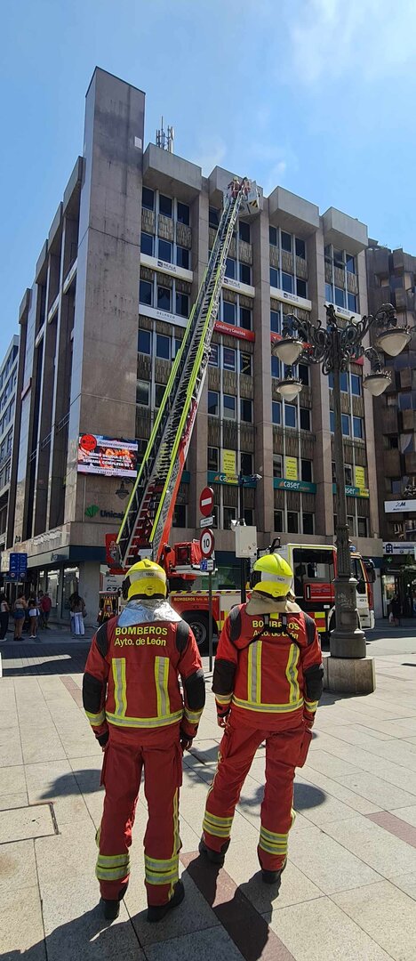 Dos bomberos observan la intervención de sus compañeros.