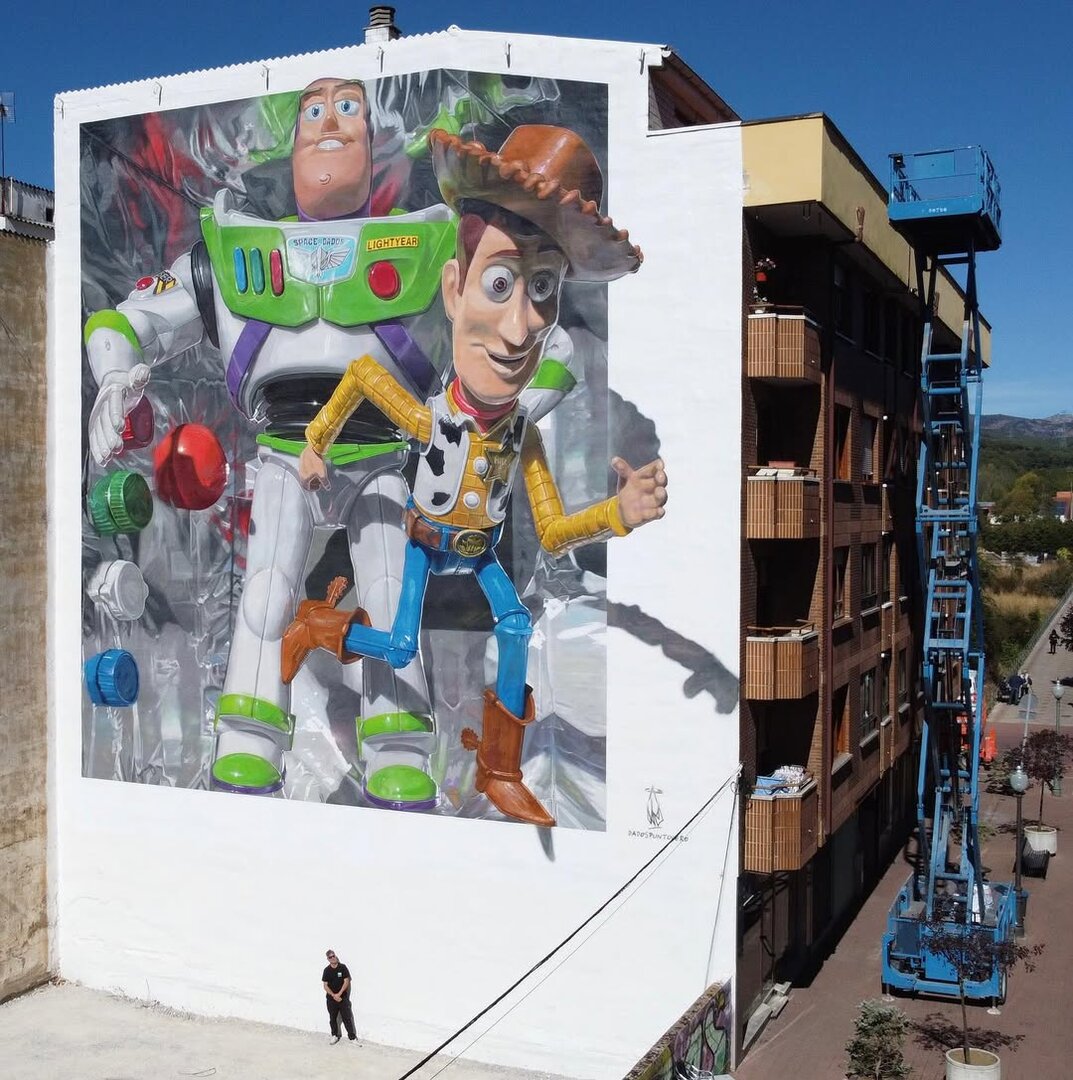 El artista Da2.0 bajo su nuevo mural en Guardo 'Plastic Toy Story'. Foto: Da2.0