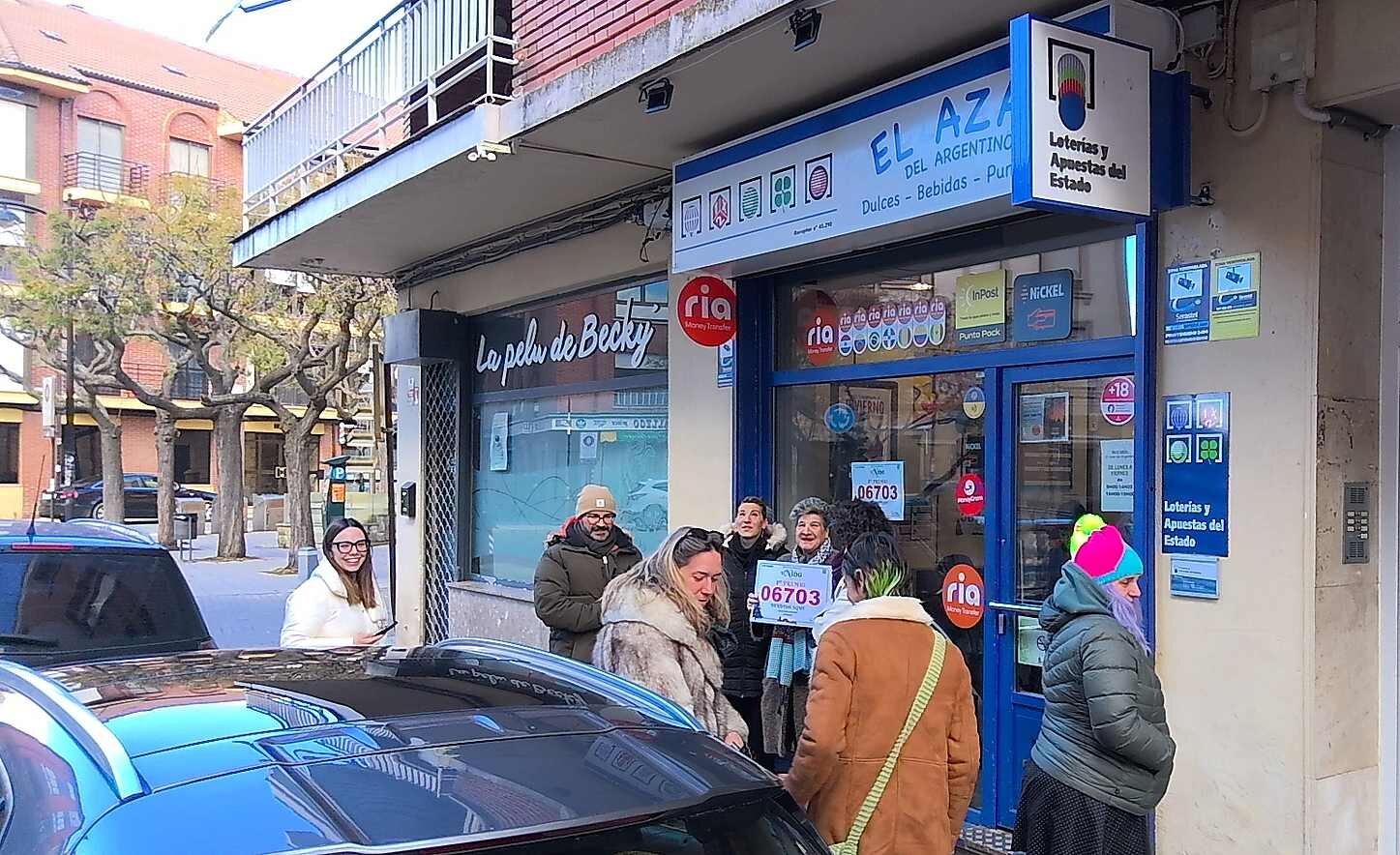 Un grupo de personas acuden al establecimiento en el que se vendieron los dos décimos.