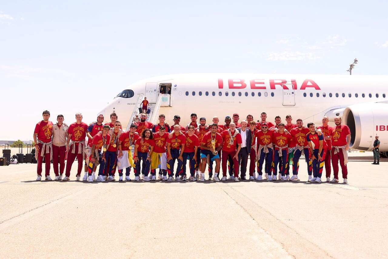 La selección forma ante el avión que les ha traído de regreso a España.