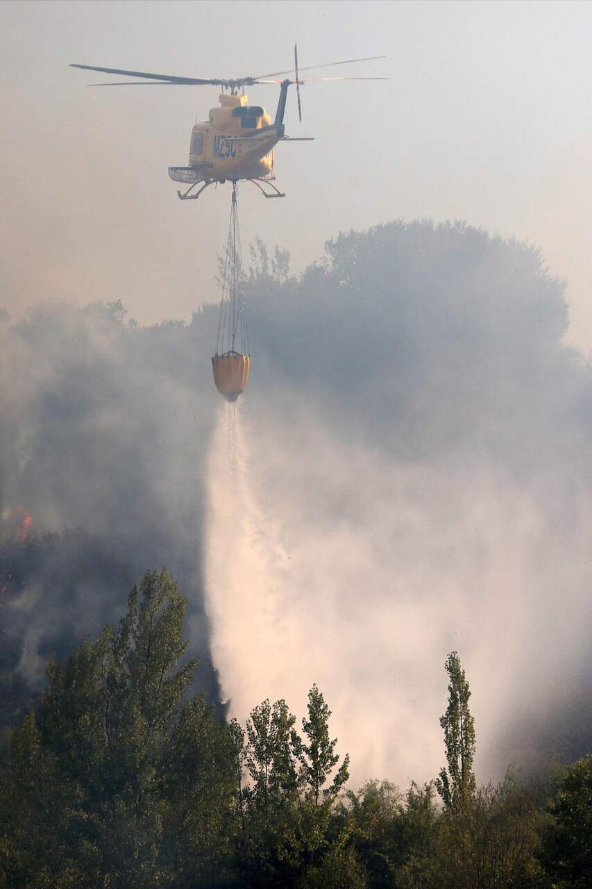 Un helicóptero durante las labores de extinción. Fotos: Peio García